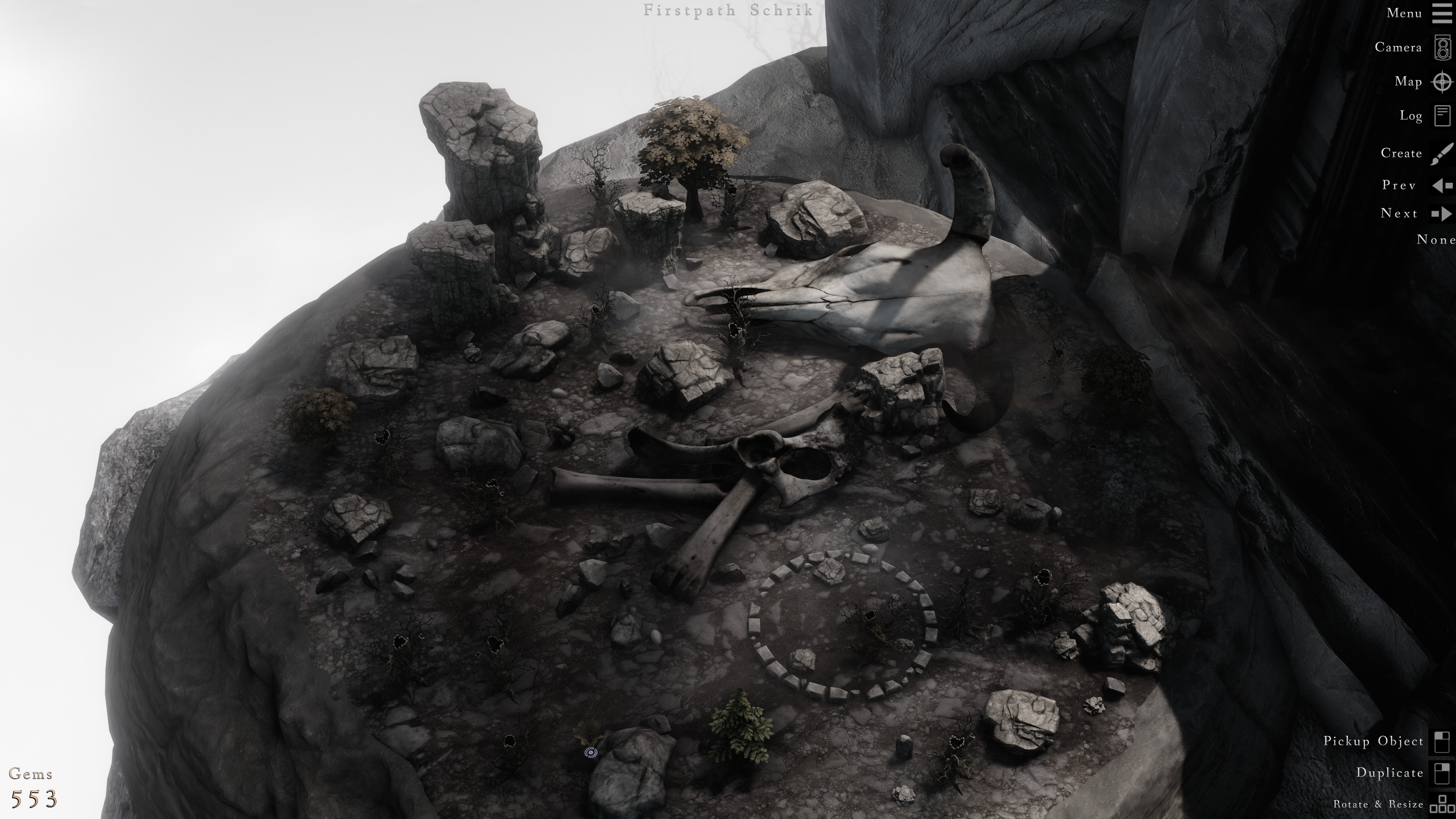 Looking down on a cliff outcropping with an oversized bull skull, large bones, and many rocks and small trees. Toward the bottom of the screenshot is a small circle of stones.